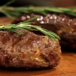 Стейк из говядины с розмарином на сковороде гриль